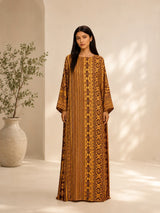 Model wearing an ALBANA New York amber silk kaftan with tonal geometric patterns, wide sleeves, and a boat neckline.