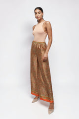 ALBANA New York apricot silk wide leg pants with a vibrant paisley print and elastic waist worn by a model.