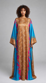 Model wearing an ALBANA New York silk kaftan with gold leopard print, turquoise panels, and pink floral accents.
