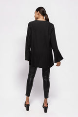 Model wearing ALBANA New York black textured crepe tunic with wide sleeves and high neck, back view
