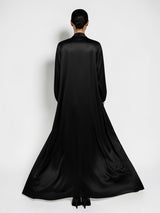 Back view of ALBANA New York black satin longline duster abaya with a flowing silhouette on a model.