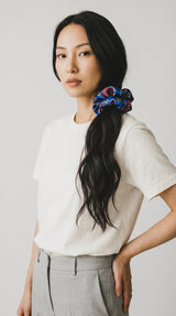 ALBANA New York oversized blue floral brocade scrunchie worn in a ponytail by a woman with long dark hair