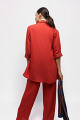Model wearing ALBANA New York coral red textured linen button-down shirt and matching wide-leg pants, back view.