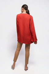 Model wearing ALBANA New York coral red textured linen tunic with high neck and wide sleeves, back view