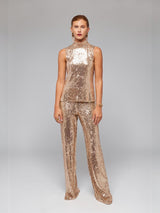 ALBANA New York gold sequin sleeveless mock neck blouse worn by a model with matching sequin trousers