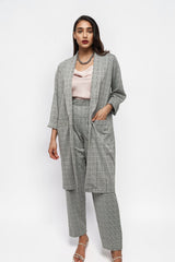 Model wearing ALBANA New York grey glen plaid relaxed fit pants and matching longline blazer with a pink camisole.