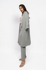 Model wearing ALBANA New York grey glen plaid relaxed fit pants and matching longline blazer with strappy heels.