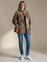 ALBANA New York Imperial Mosaic silk coat with earthy patterned panels, gold trim, and pockets, worn with blue jeans.