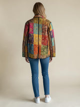 Model wearing ALBANA New York Imperial Mosaic Silk Jacket with colorful patchwork pattern and black noir trim.