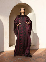 Model wearing an ALBANA New York Imperial Wine silk kaftan with a boat neckline, wide sleeves, and tonal patterning.