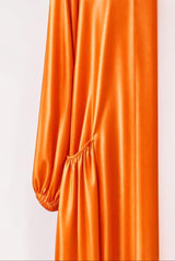 ALBANA New York orange satin abaya featuring gathered side pockets and long sleeves in a smooth, lustrous fabric.