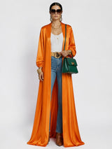 ALBANA New York orange satin maxi duster abaya worn over a white top and blue jeans with a green handbag