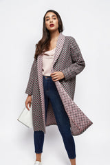 Model wearing an ALBANA New York longline open-front coat with a geometric print and contrasting pink inner lining.