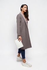 ALBANA New York longline open-front coat with geometric print, worn by a model with jeans and white sneakers.