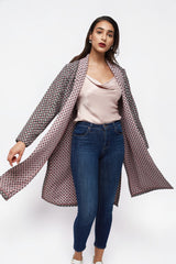 ALBANA New York longline open front coat with a geometric print and contrasting pink lining worn by a model.