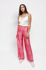 Model wearing ALBANA New York rose pink silk wide leg pants with a vibrant paisley print and elastic waistband.