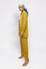 Model wearing ALBANA New York saffron yellow textured linen wide leg pants and matching long sleeve button-down shirt.