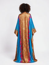 Back view of a model wearing an ALBANA New York satin kaftan with gold leopard print and vibrant turquoise panels.