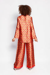 Model wearing ALBANA New York Mandarin Scrolls silk tunic and matching wide-leg pants with vibrant red floral pattern