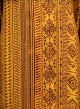 Close-up of ALBANA New York amber silk kaftan featuring intricate tonal geometric and tribal patterns.