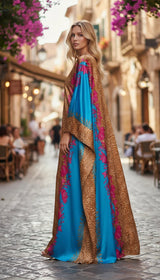 Model wearing an ALBANA New York silk kaftan with a gold leopard print, turquoise panels, and pink floral details.