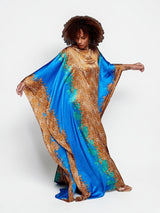 ALBANA New York Sahara Azure satin kaftan with vibrant blue and gold animal print, wide sleeves, and flowing silhouette.