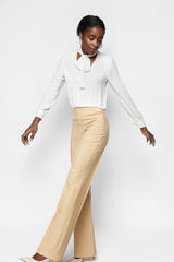 ALBANA New York high-waisted beige pinstripe flare trousers worn by a model in a white blouse