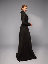 ALBANA New York black matelassé opera coat with ruffled collar and floor-length structured silhouette on a model