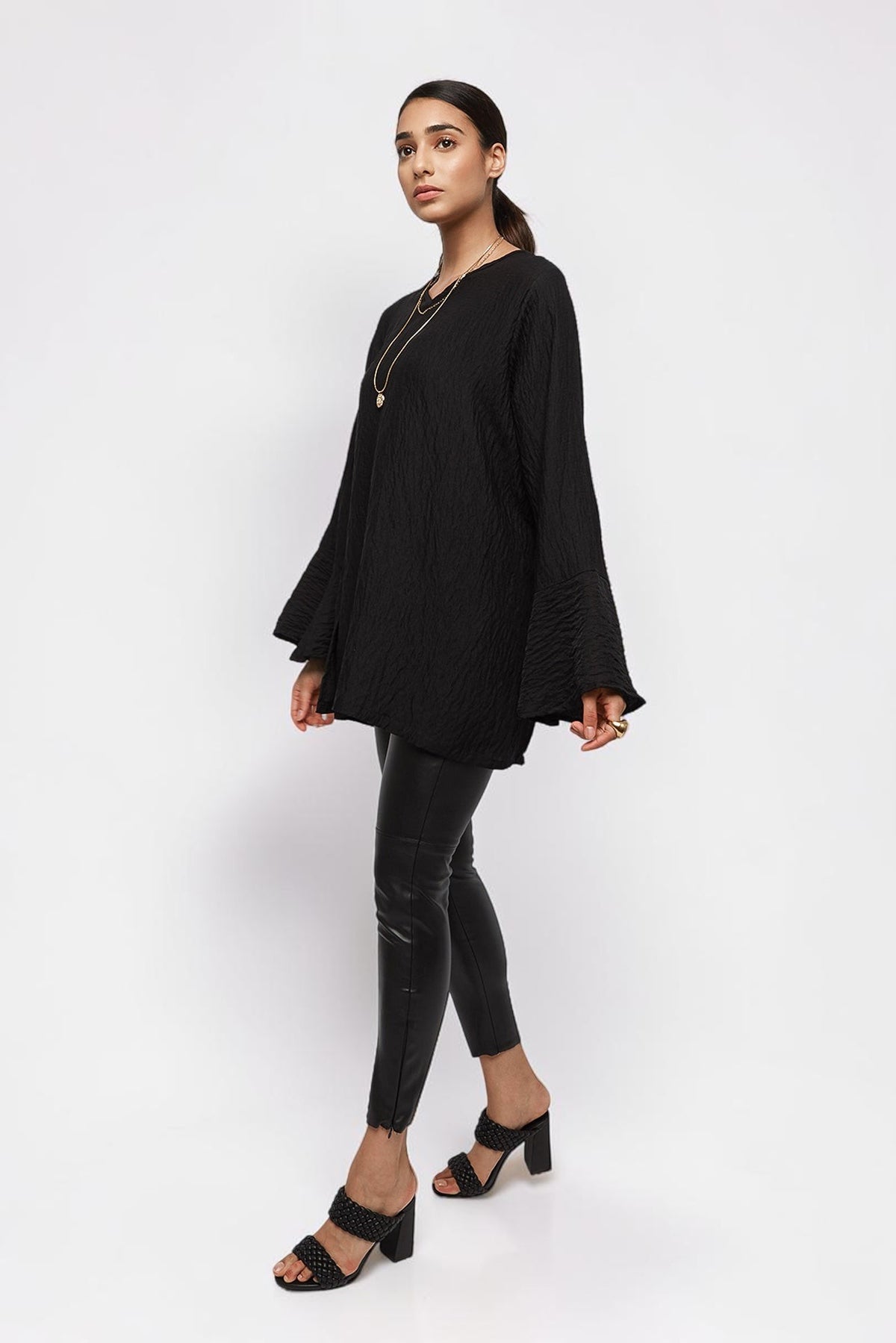 ALBANA New York black textured crepe tunic with wide sleeves and high neck worn by a model with black trousers