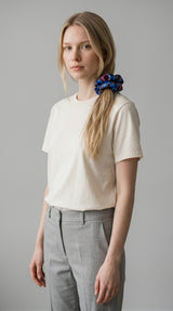 ALBANA New York oversized blue floral brocade scrunchie worn in a blonde model's ponytail for a chic hairstyle.