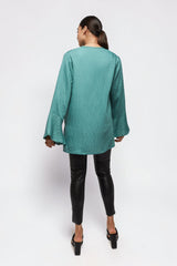 Model wearing ALBANA New York la mer blue textured linen tunic with wide sleeves and high neck, back view