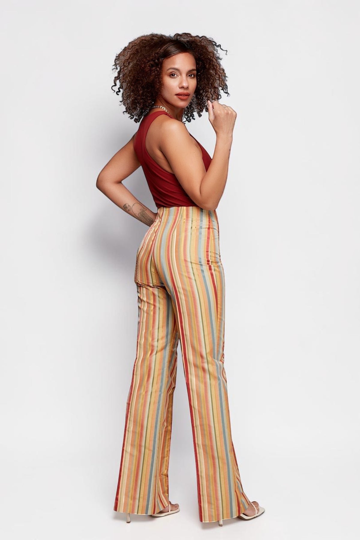 ALBANA New York Carousel Stripe Pants featuring a multi-directional stripe pattern, mid-rise waist, and flared leg.