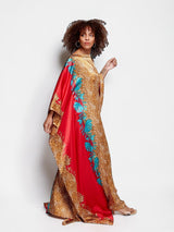 ALBANA New York crimson satin kaftan with gold leopard print and turquoise floral accents on a cobblestone street.
