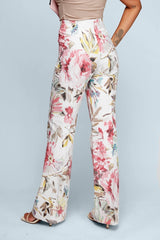 ALBANA New York mid-rise flare pants in white cotton with a blush floral print, shown from a rear angle.