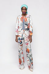 ALBANA New York floral print flare pants and matching jacket worn by a model with a turquoise headwrap.
