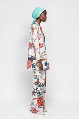 ALBANA New York Fruit and Florals flare pants in white cotton with a vibrant botanical print and double pleat detail.