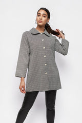 Model wearing an ALBANA New York black and white geometric textured button-down collared jacket with long sleeves.