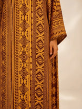 ALBANA New York Gilded Amber silk kaftan featuring intricate tonal geometric patterns and wide sleeves.