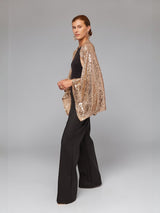 ALBANA New York gold sequin bolero sleeves worn over a black sleeveless top and trousers for an elegant evening look.