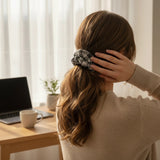 ALBANA New York oversized black and white houndstooth knit scrunchie worn in a ponytail by a woman at a desk