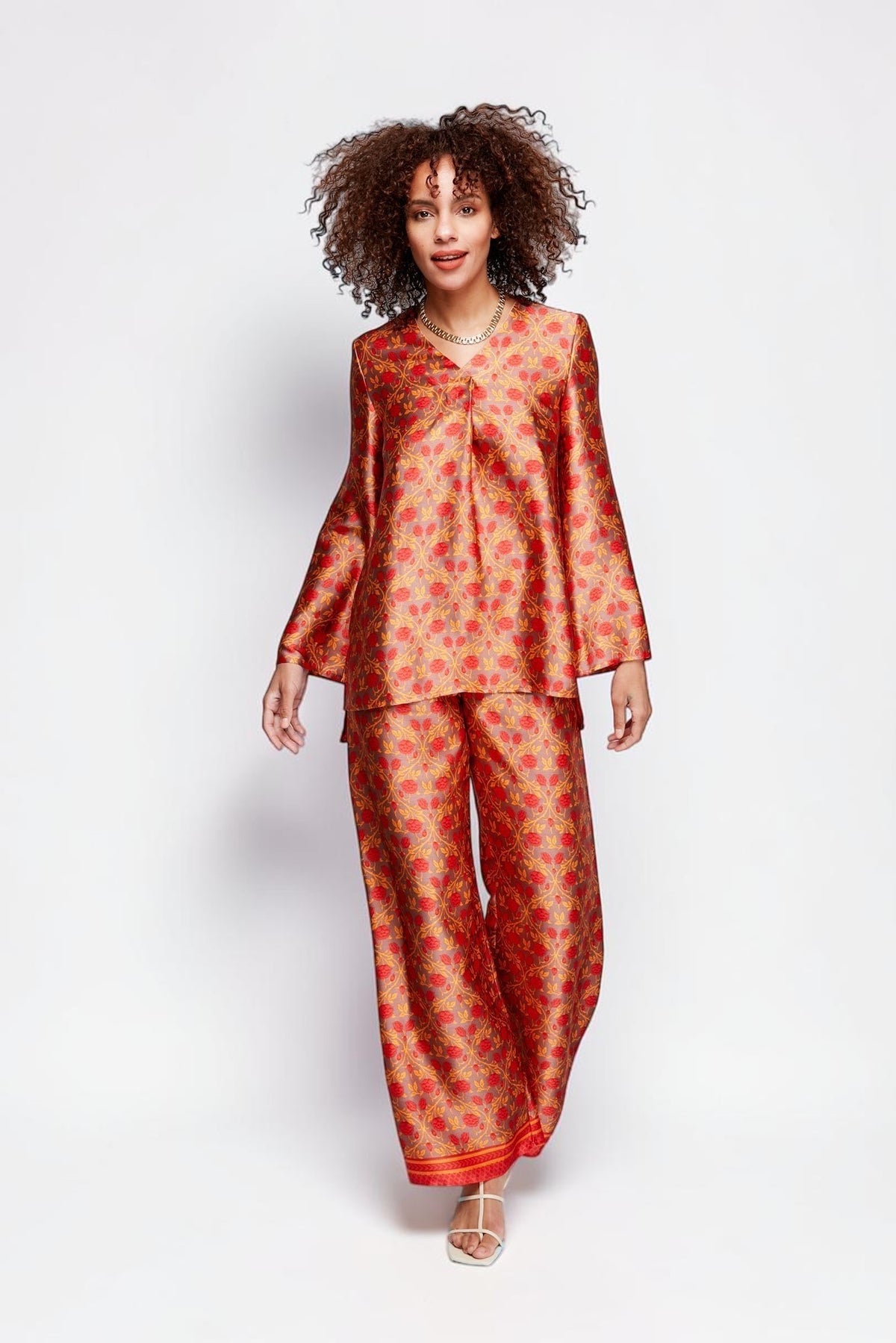 ALBANA New York Mandarin Scrolls silk tunic and matching trousers in vibrant red and gold floral print on a model.