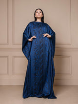 Model wearing an ALBANA New York midnight blue silk kaftan with wide sleeves, boat neckline, and tonal floral pattern.