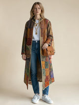 Model wearing ALBANA New York Imperial Mosaic Silk Long Coat with earthy patchwork patterns and contrast gold trim.