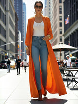 ALBANA New York orange satin maxi duster abaya worn over jeans and a white top on a city street