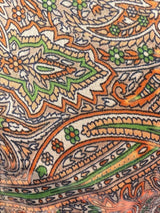 ALBANA New York silk kaftan fabric featuring an intricate paisley print in orange, green, and cream tones.