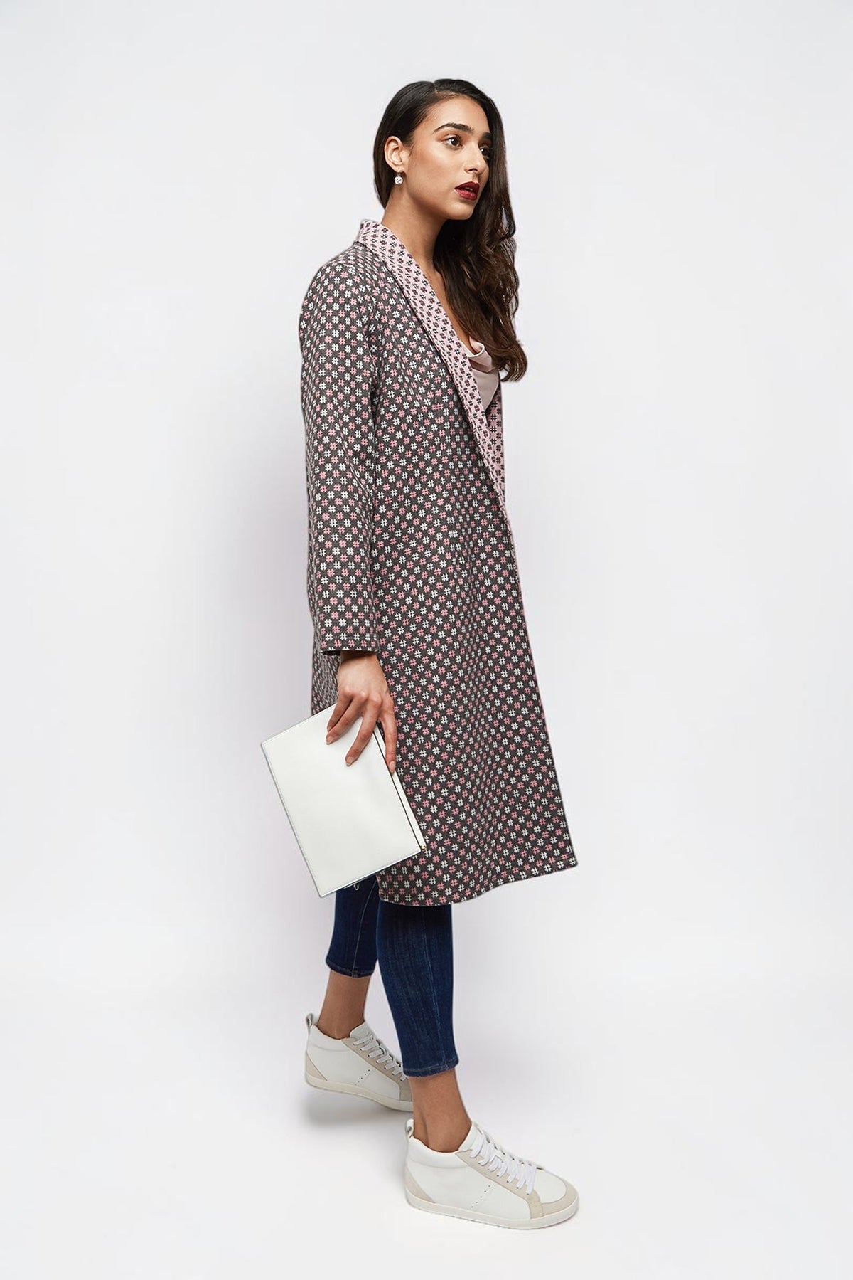 ALBANA New York longline open-front coat with geometric print, worn by a model with jeans and white sneakers.