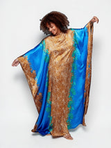 ALBANA New York Sahara Azure satin kaftan featuring a vibrant blue and gold leopard print with wide flowing sleeves.