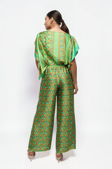 ALBANA New York silk wide leg pants in green and gold floral print with matching top, worn by a model from behind.