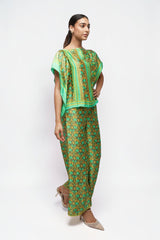 ALBANA New York silk wide leg pants and matching top in vibrant green and gold ethnic print on a model