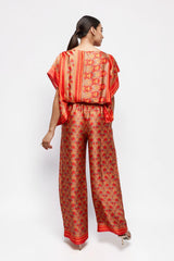 ALBANA New York silk wide leg pants with vibrant red and orange floral patterns and elastic waist, back view